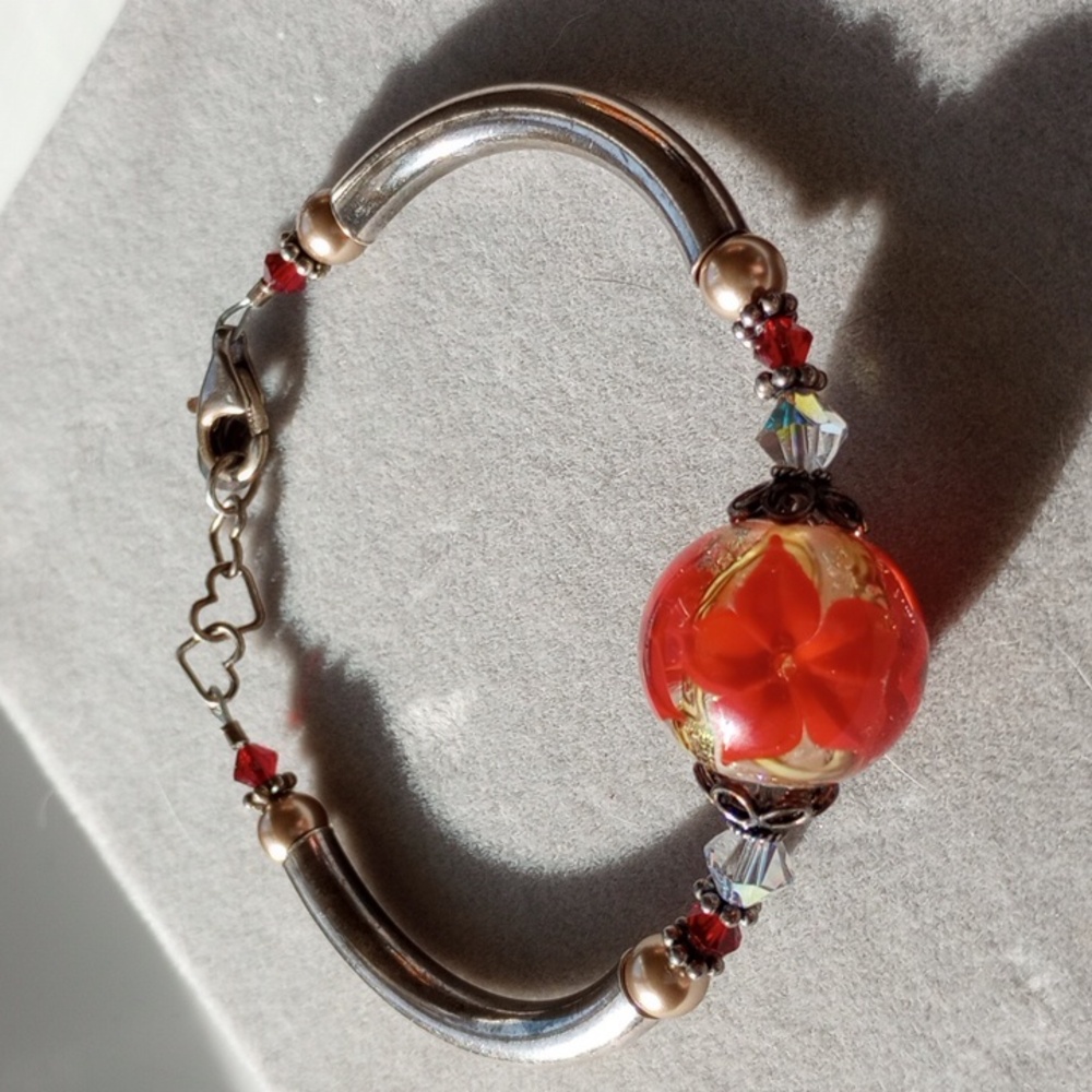 Marked Poinsettia glass art bead with silver tone bangle looking clasp bracelet